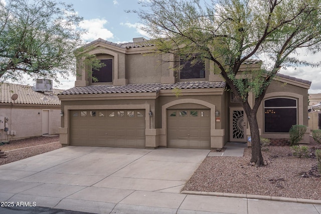 view of front of house featuring a tiled roof, stucco siding, an attached garage, and driveway