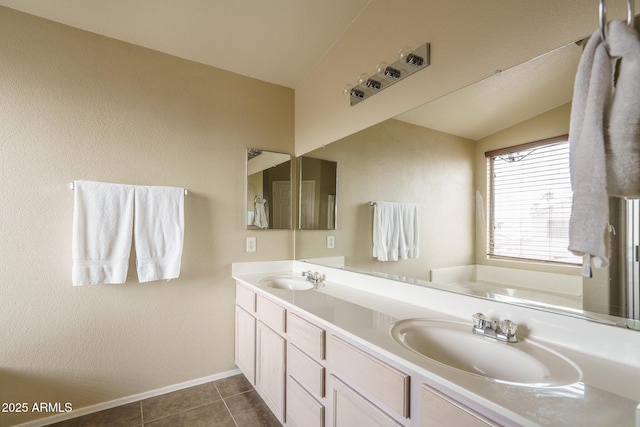 full bath featuring tile patterned floors, double vanity, lofted ceiling, and a sink