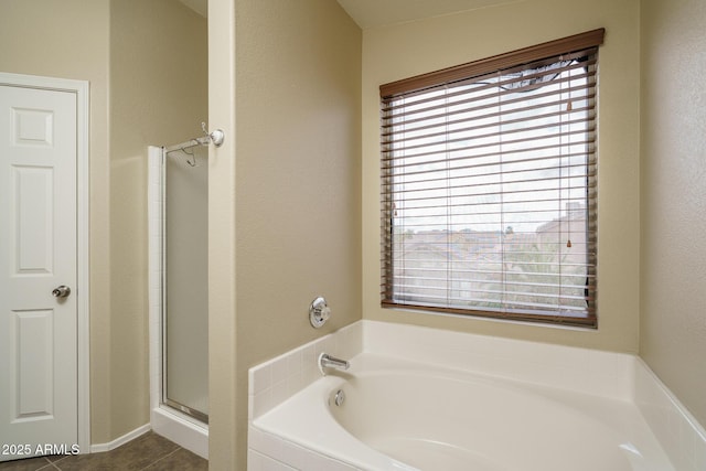 bathroom featuring a garden tub, a stall shower, and tile patterned flooring