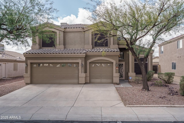 view of front facade with a tile roof, an attached garage, driveway, and stucco siding