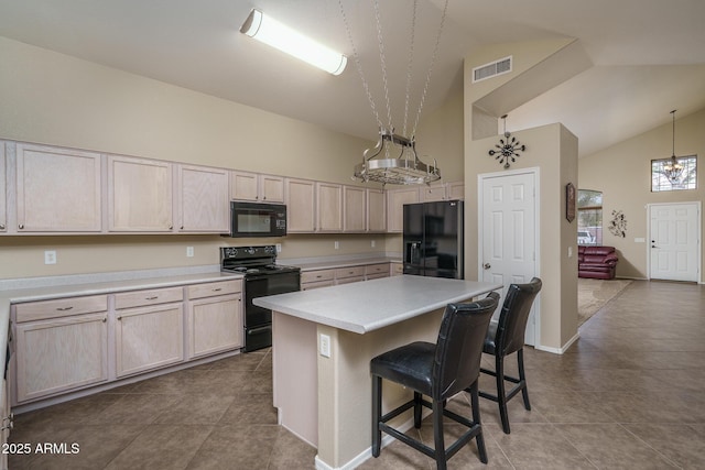 kitchen with visible vents, high vaulted ceiling, black appliances, a breakfast bar area, and light countertops