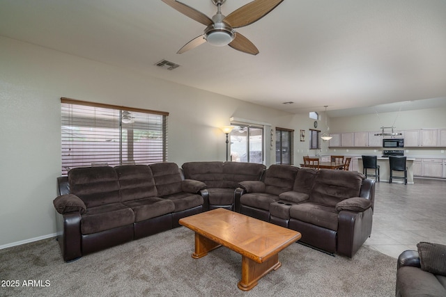 living room with visible vents, a healthy amount of sunlight, baseboards, and a ceiling fan