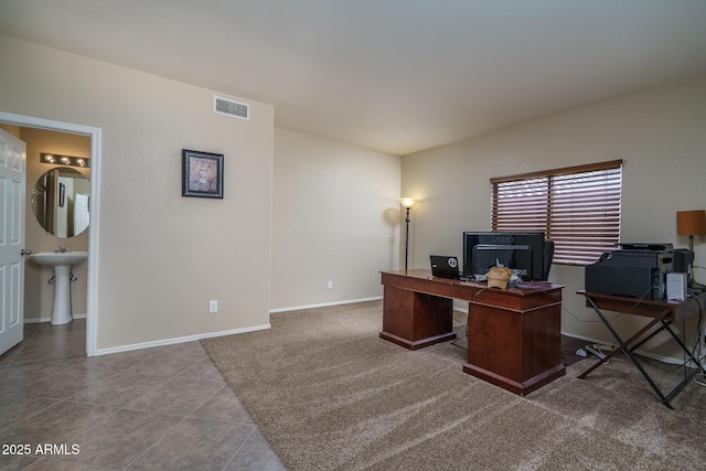 carpeted home office with tile patterned floors, baseboards, visible vents, and a sink