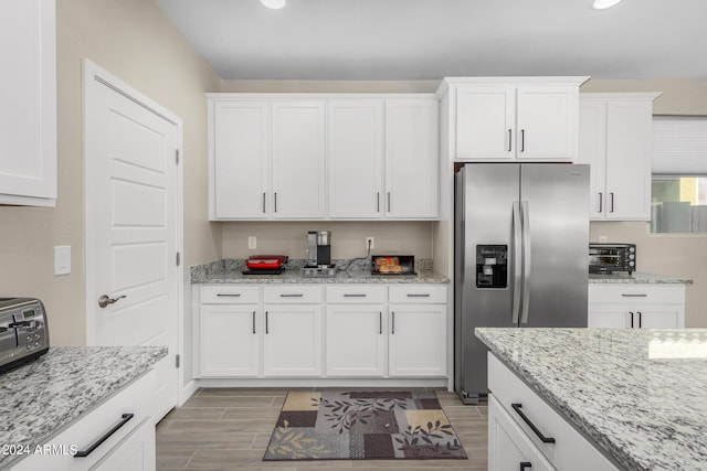 1906 W Lariat Ln, Phoenix, AZ 85085 - kitchen with stainless steel fridge with ice dispenser, white cabinets, wood finish floors, and light stone countertops