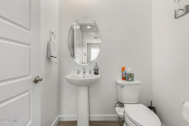 bathroom with wood-type flooring and toilet