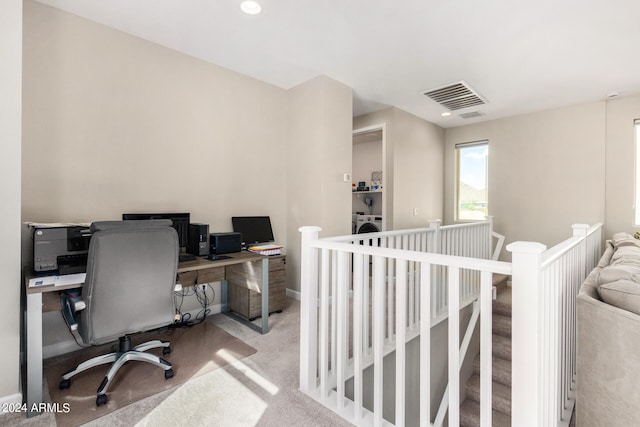 office space with washer / dryer and light colored carpet