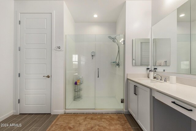 bathroom featuring hardwood / wood-style floors, an enclosed shower, and vanity