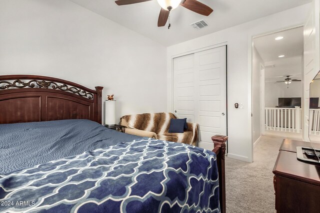 carpeted bedroom featuring a closet, lofted ceiling, and ceiling fan