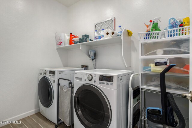 clothes washing area with light wood-type flooring and washer and dryer