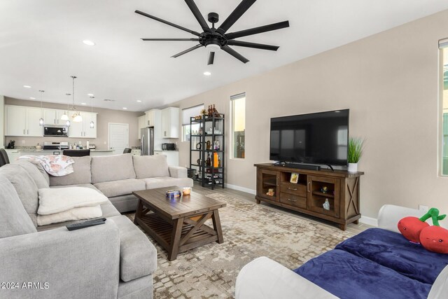 living room with light hardwood / wood-style floors, ceiling fan, and plenty of natural light