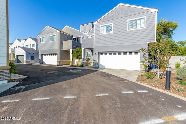 view of front of house featuring a residential view, driveway, an attached garage, and stucco siding