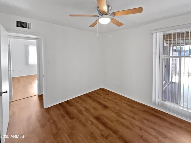 spare room with plenty of natural light, hardwood / wood-style floors, and ceiling fan