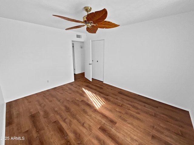 empty room featuring dark wood-type flooring and ceiling fan