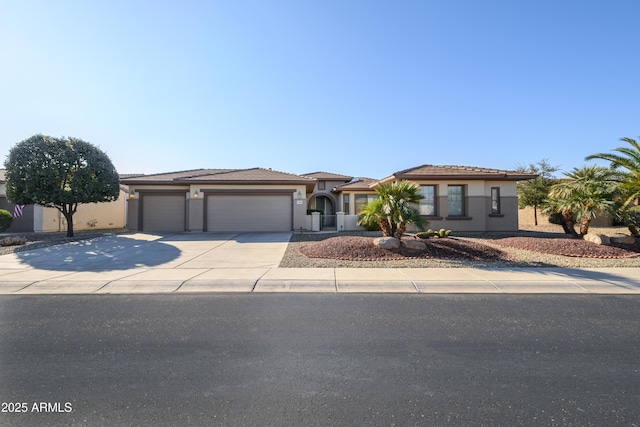 view of front of property with an attached garage, stucco siding, and driveway