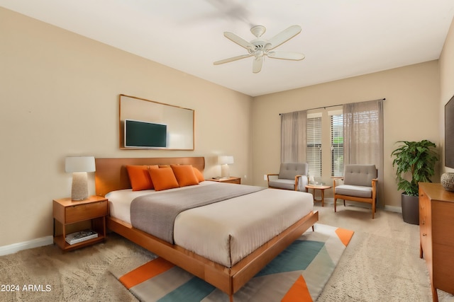 bedroom featuring a ceiling fan, light carpet, and baseboards