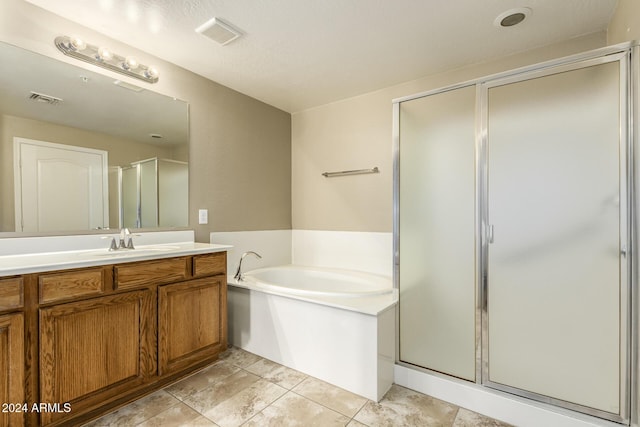 bathroom featuring a garden tub, vanity, a shower stall, and visible vents