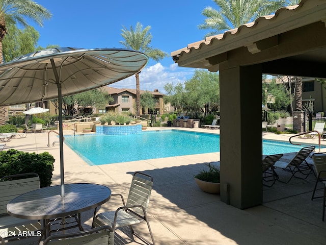 community pool featuring a patio and fence