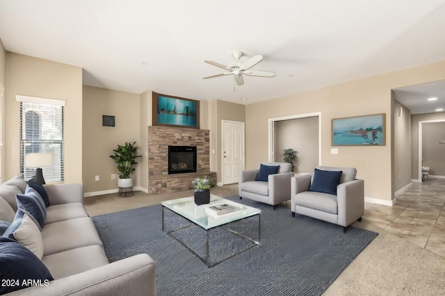 living area featuring ceiling fan, a fireplace, baseboards, and carpet flooring