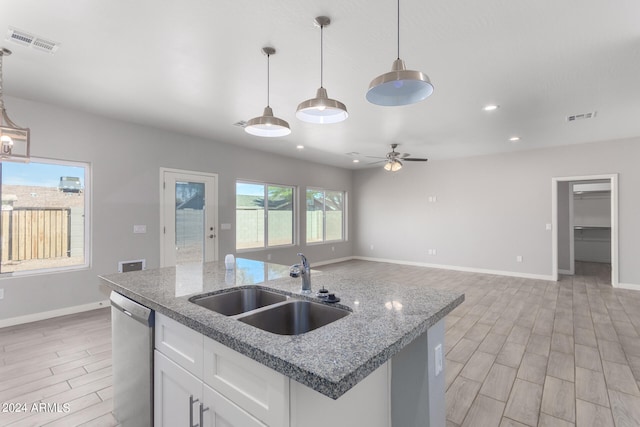 kitchen with white cabinets, sink, light hardwood / wood-style floors, pendant lighting, and dishwasher