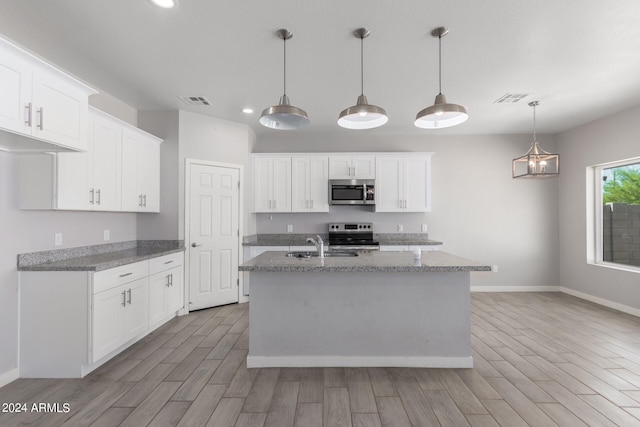 kitchen with a center island with sink, appliances with stainless steel finishes, light hardwood / wood-style floors, and white cabinetry