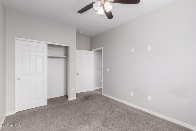 unfurnished bedroom with a closet, carpet flooring, and ceiling fan