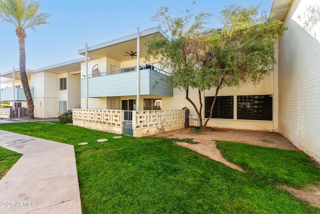 exterior space featuring a yard, a balcony, and ceiling fan