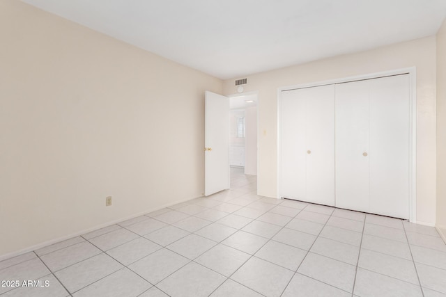 unfurnished bedroom featuring light tile patterned flooring and a closet