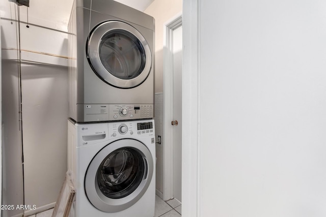 washroom featuring light tile patterned floors and stacked washer and clothes dryer