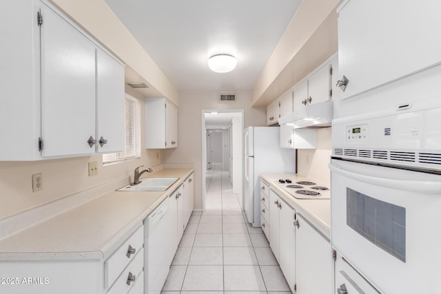 kitchen featuring white cabinetry, sink, white appliances, and light tile patterned flooring