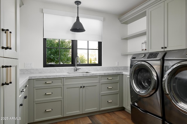 washroom featuring sink, cabinets, washer and clothes dryer, and dark wood-type flooring