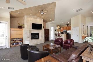 11375 E Sahuaro Dr Unit 2064, Scottsdale, AZ 85259 - living area featuring a ceiling fan, a large fireplace, vaulted ceiling, and carpet floors