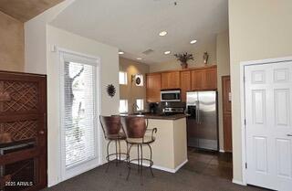11375 E Sahuaro Dr Unit 2064, Scottsdale, AZ 85259 - kitchen featuring appliances with stainless steel finishes, a peninsula, dark carpet, healthy amount of natural light, and recessed lighting
