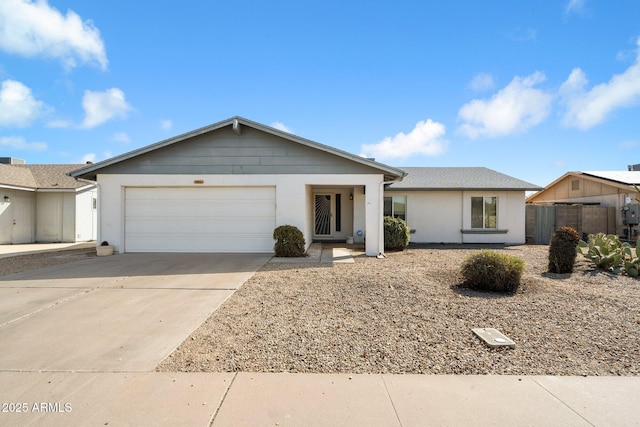 ranch-style house featuring a garage, concrete driveway, stucco siding, and fence