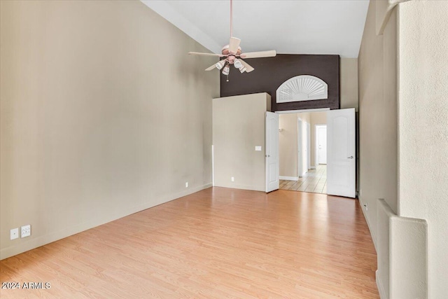 empty room featuring ceiling fan, high vaulted ceiling, and light hardwood / wood-style floors