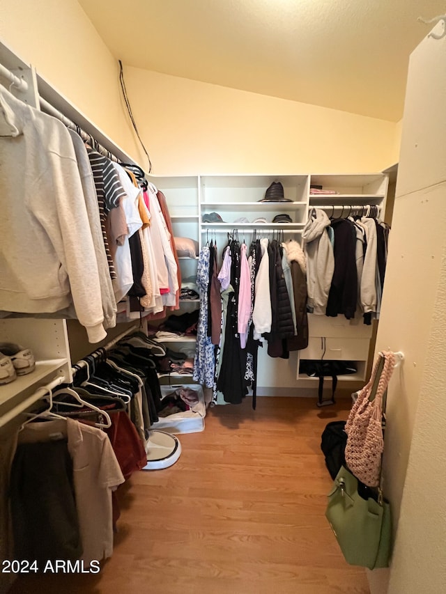 spacious closet featuring light wood-type flooring and vaulted ceiling