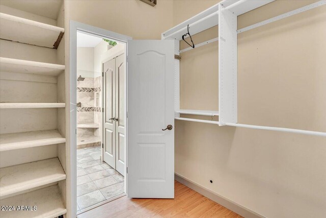 walk in closet with hardwood / wood-style floors