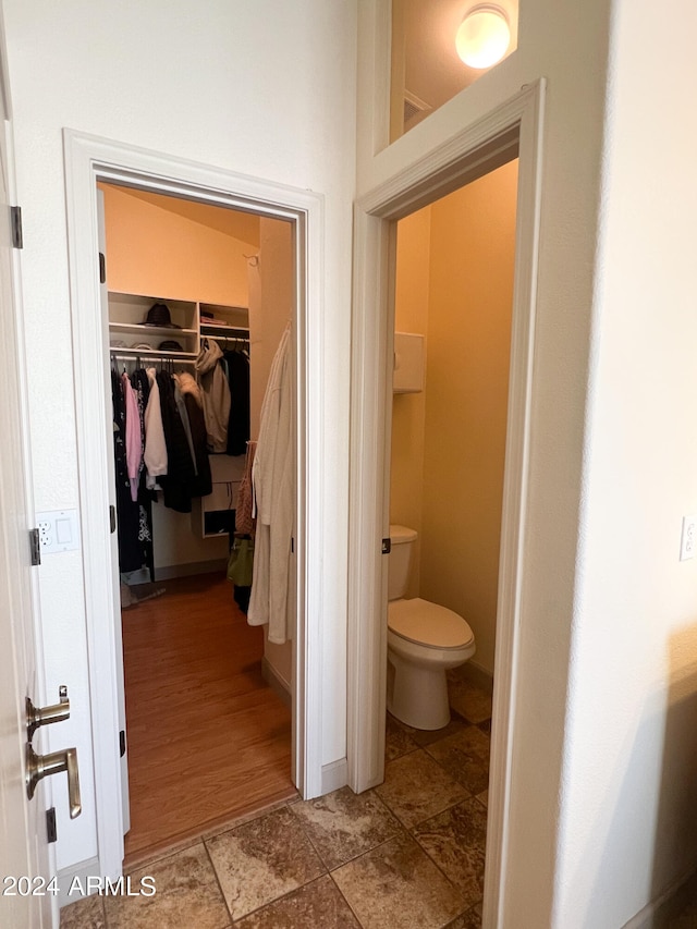 bathroom featuring wood-type flooring and toilet