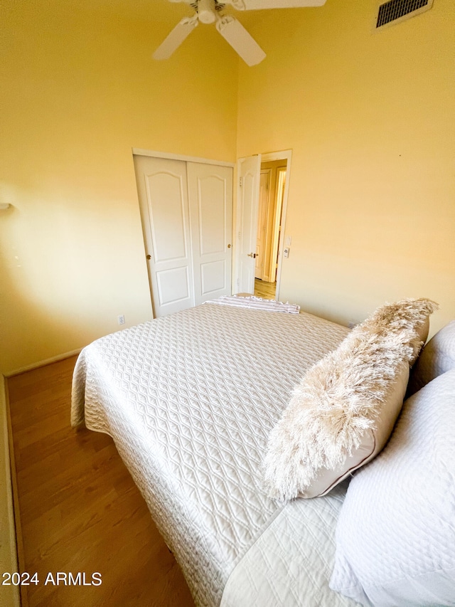 bedroom with a closet, hardwood / wood-style floors, and ceiling fan