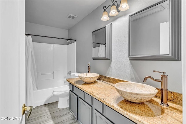 full bathroom with shower / tub combo with curtain, vanity, and toilet