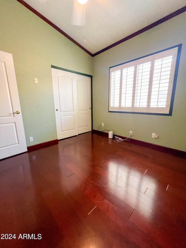 unfurnished bedroom featuring vaulted ceiling, hardwood / wood-style flooring, ceiling fan, ornamental molding, and a closet