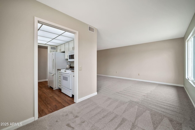 unfurnished living room with dark colored carpet