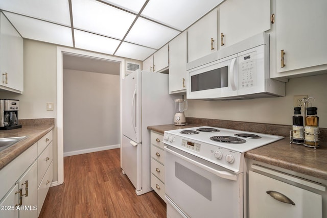 kitchen with white cabinetry, white appliances, and light hardwood / wood-style floors