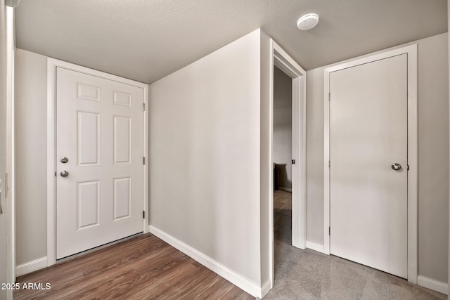 hallway with dark hardwood / wood-style floors and a textured ceiling