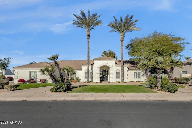 mediterranean / spanish-style home with a front lawn