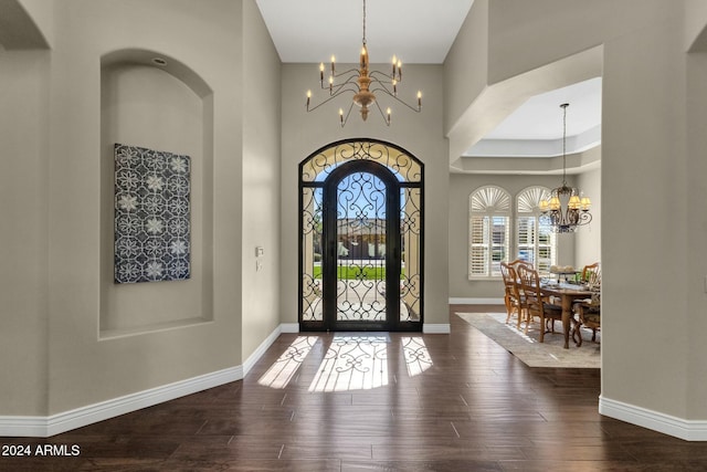 entrance foyer with hardwood / wood-style flooring, a high ceiling, and an inviting chandelier