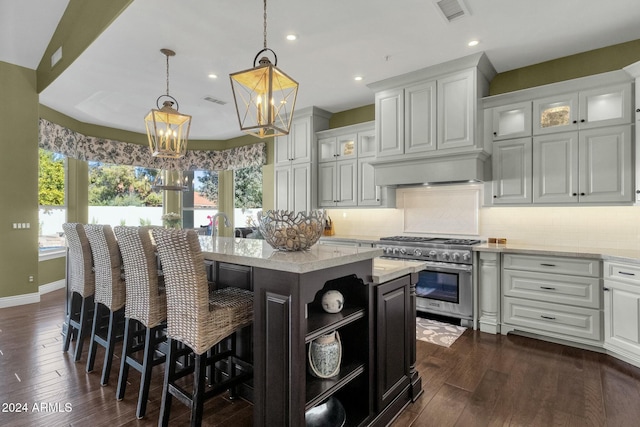 kitchen featuring hanging light fixtures, high end stainless steel range oven, a kitchen island, dark hardwood / wood-style flooring, and white cabinets