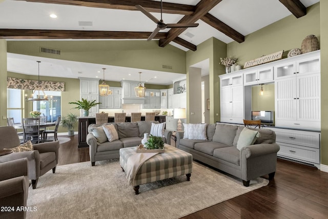 living room featuring hardwood / wood-style flooring, ceiling fan with notable chandelier, and beamed ceiling