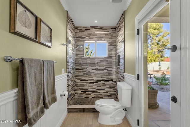 bathroom with tiled shower, hardwood / wood-style flooring, toilet, and plenty of natural light