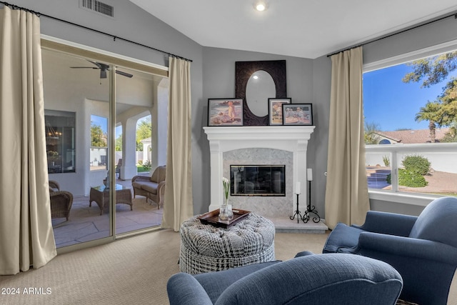 carpeted living room with a fireplace, vaulted ceiling, a wealth of natural light, and ceiling fan