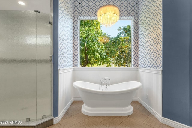 bathroom featuring separate shower and tub and an inviting chandelier